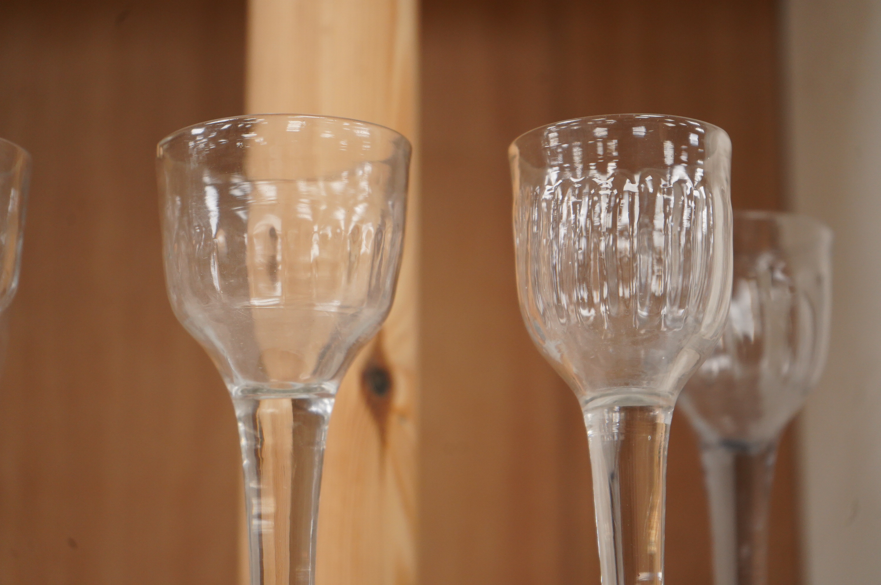 Five 18th century cordial glasses, in lead and soda glass, with fluted bowls, columnar stems, on domed and folded feet, 13.5cm high